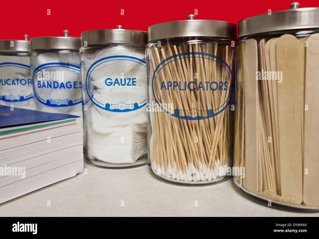 Ligne de contenants en verre de gazes, bandes et spatules et livre médical. Utilisé par le médecin pour traiter et diagnostiquer. Banque D'Images