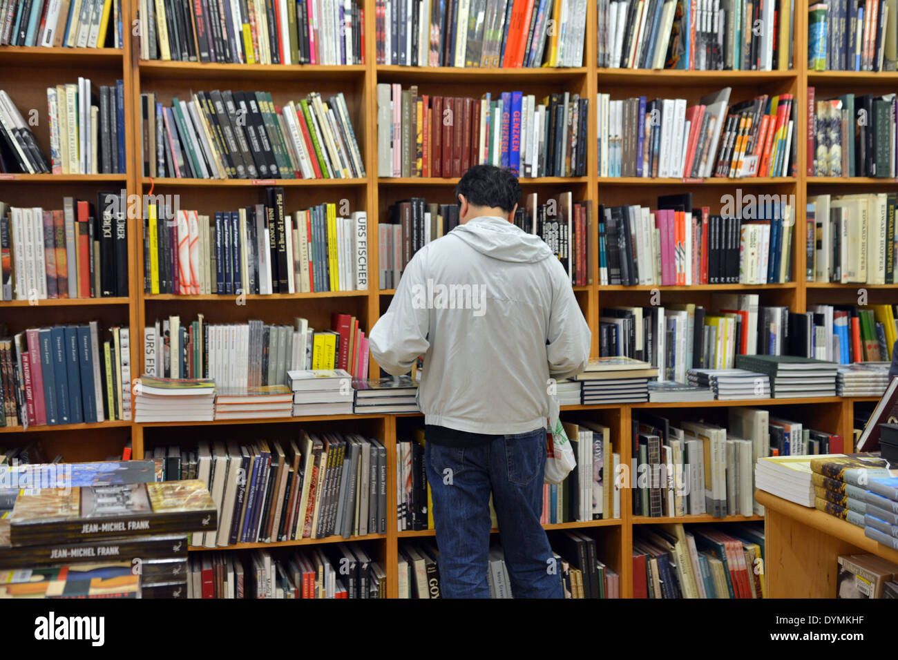 Un homme en noir shopping pour des livres à la librairie Strand à Broadway dans Greenwich Village, Manhattan, New York. Banque D'Images