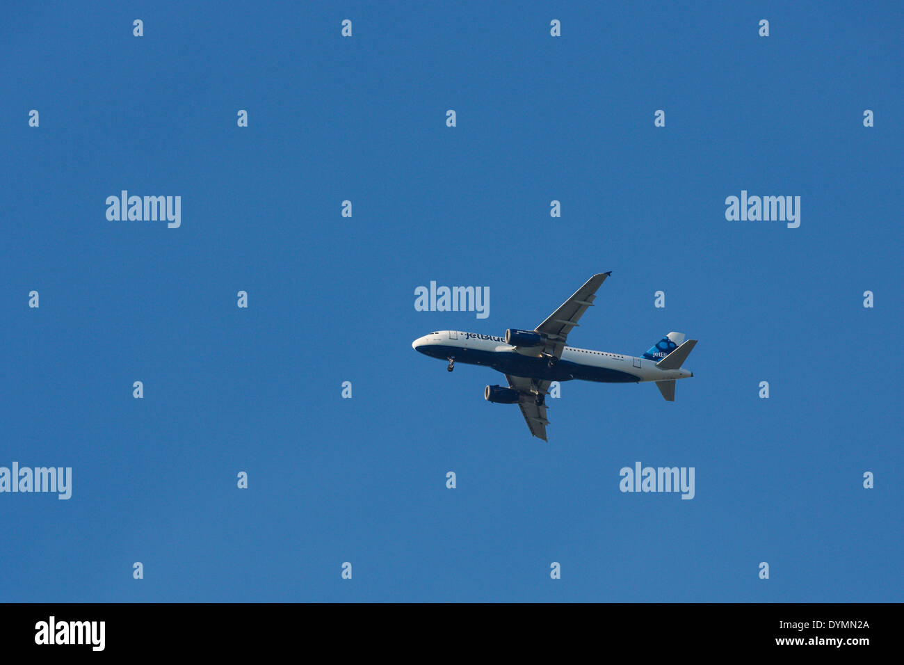 Blue jet avion de passagers avec les roues vers le bas pour l'atterrissage contre clair ciel bleu profond Banque D'Images