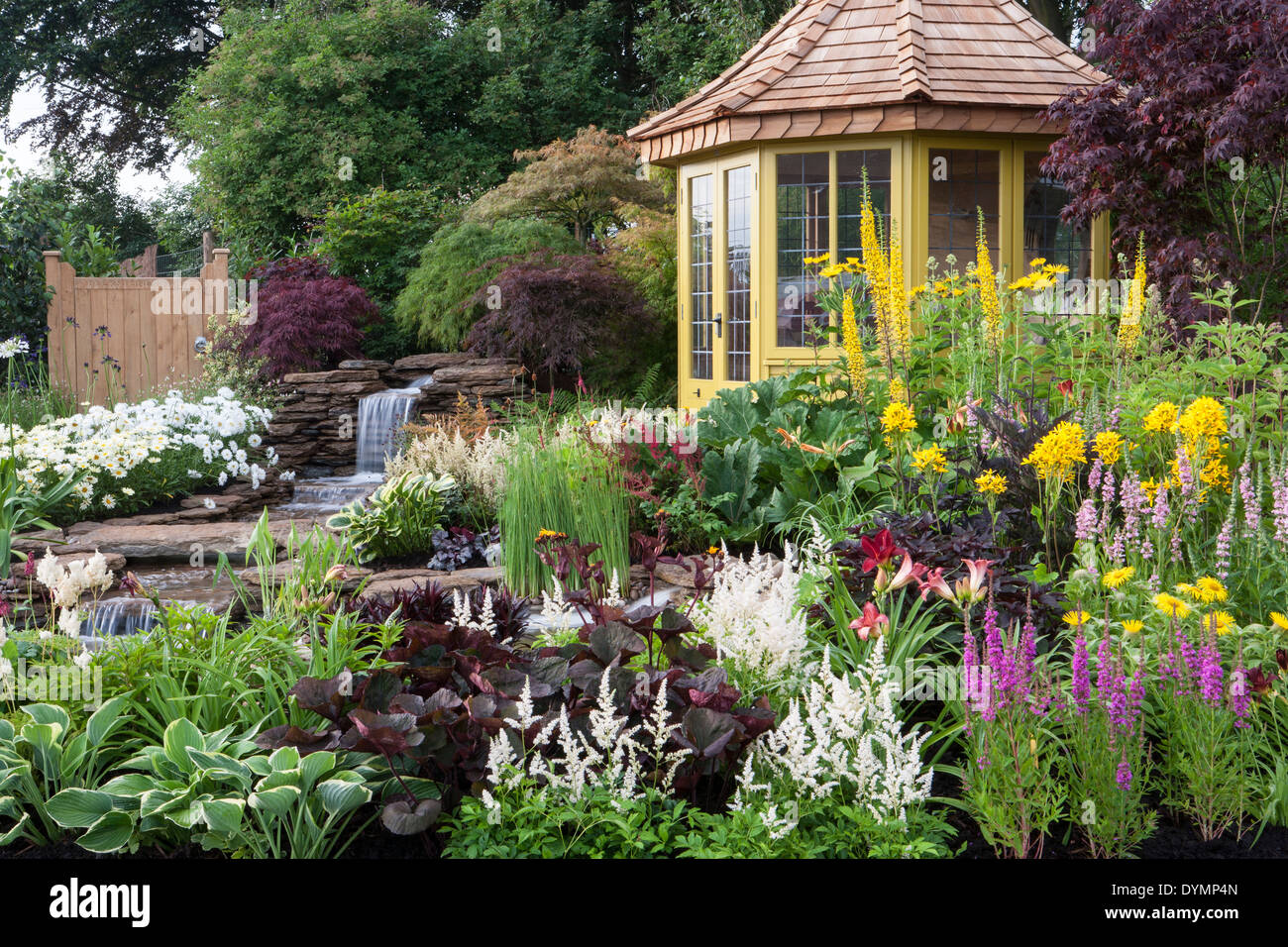 Campagne anglaise cottage jardin d'été avec maison d'été cabane petit étang eau avec cascade mélangée bordure fleurie colorée frontières Royaume-Uni Banque D'Images