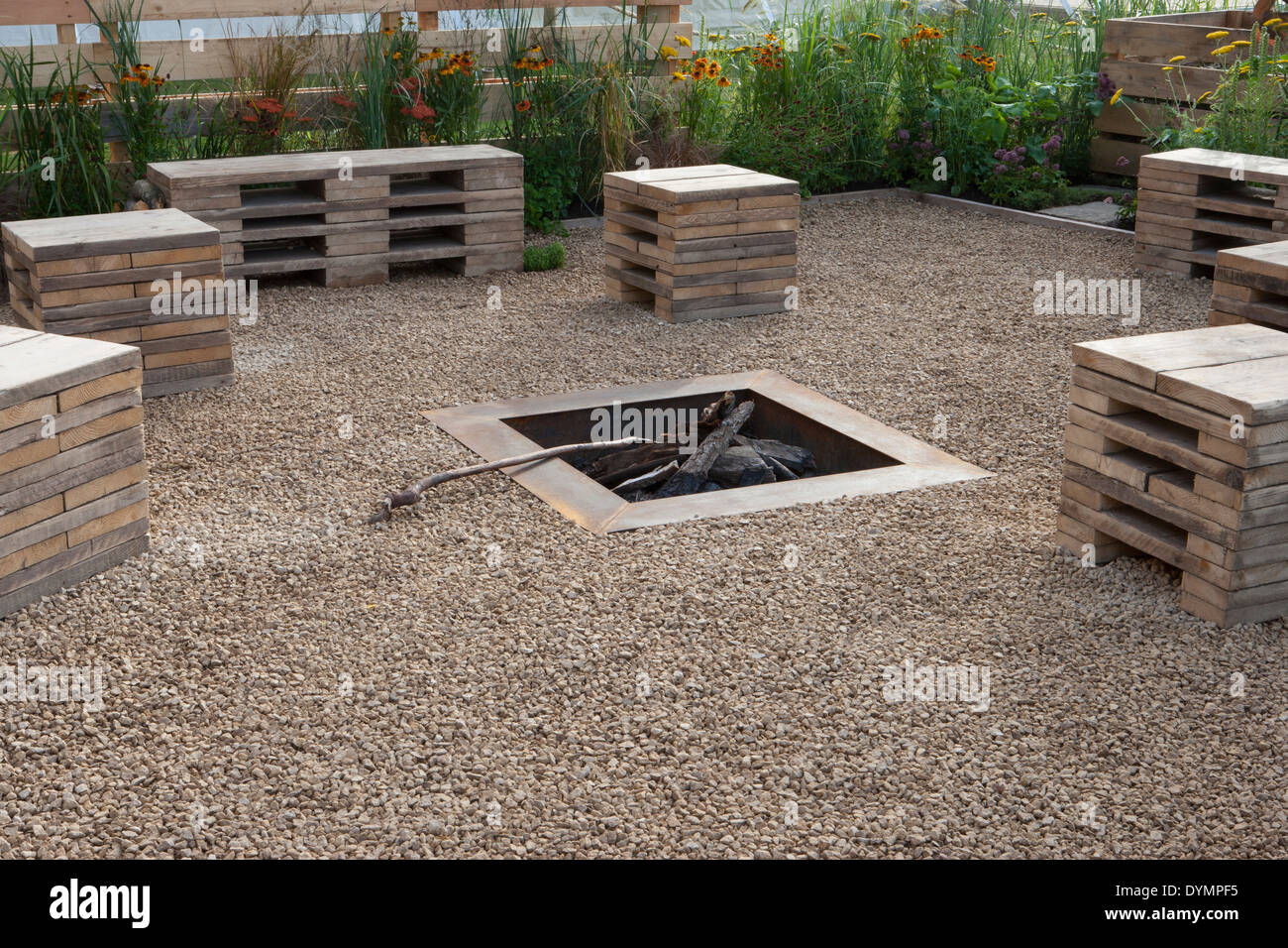 Jardin écologique avec banquettes en matériaux recyclés - palettes dans une zone de gravier avec foyer extérieur à foyer Angleterre Royaume-Uni Banque D'Images