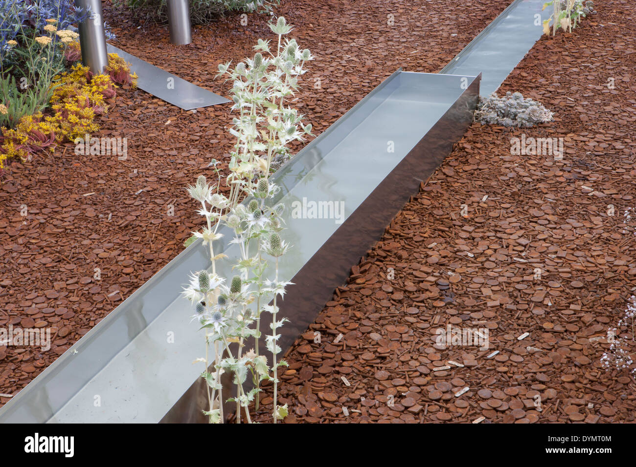 Jardin contemporain moderne avec eau de rill de jardin fait en acier courant à travers un jardin de gravier Royaume-Uni Banque D'Images