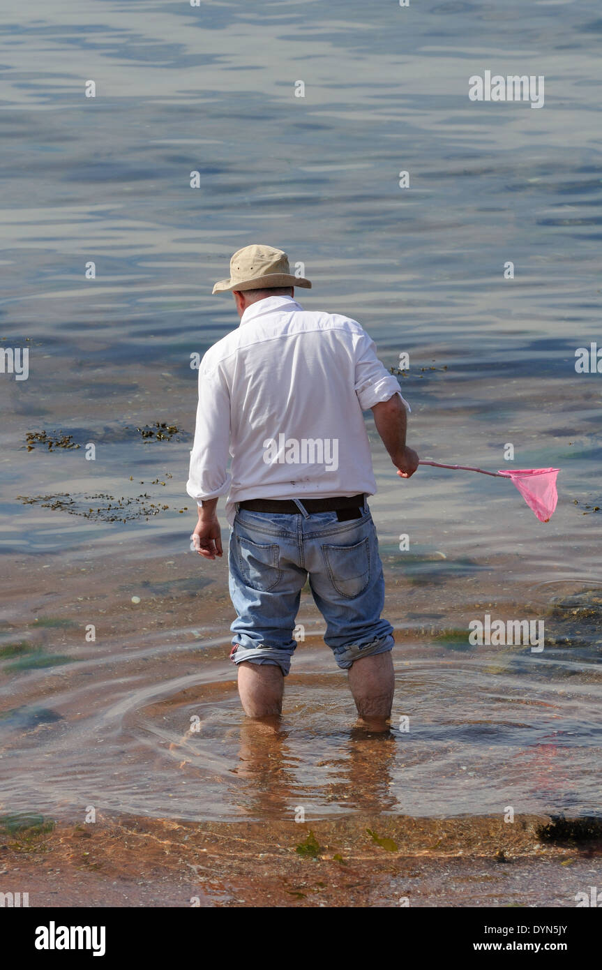 La pagaie dans l'homme avec l'enfant de la mer filet de pêche. Banque D'Images