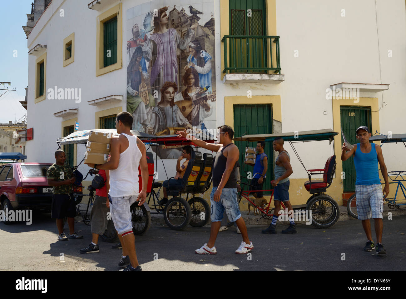 Scène de rue animée des chauffeurs de taxi et les vendeurs avec de belles photo murale dans la vieille Havane Cuba Banque D'Images