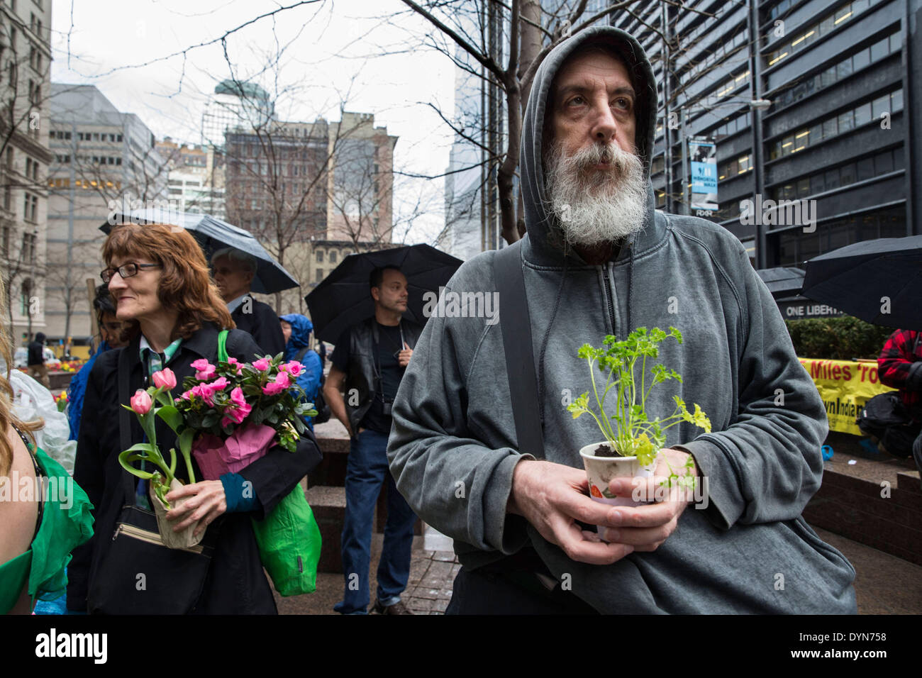 New York, USA. 22 avril 2014. Les militants de l'environnement participer à une manifestation à Zuccotti Park sur le jour de la Terre. Les manifestants ont scandé des plantes, et ''un changement de système pas le changement climatique, en tenant ' visent à de grandes entreprises qui n'adhèrent pas aux préoccupations environnementales. Les manifestants ont également exprimé que capatilisim l'exploitation de la nature est le revers à l'exploitation du travail humain. Crédit : Scott Houston/Alamy Live News Banque D'Images