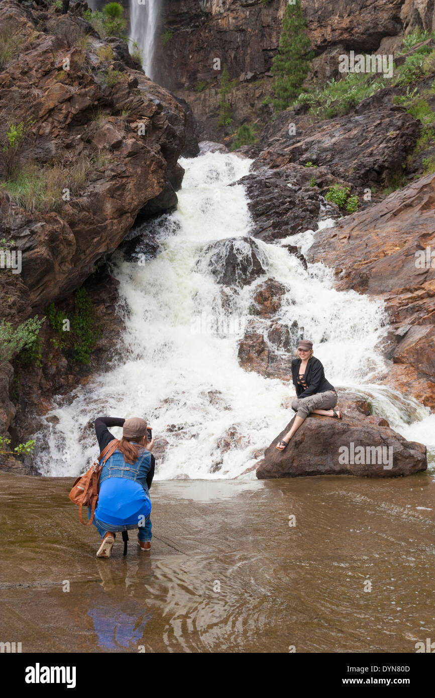 Les femmes qui posent pour des photos près de mountain waterfall sur Gran Canaria, Îles Canaries, Espagne Banque D'Images