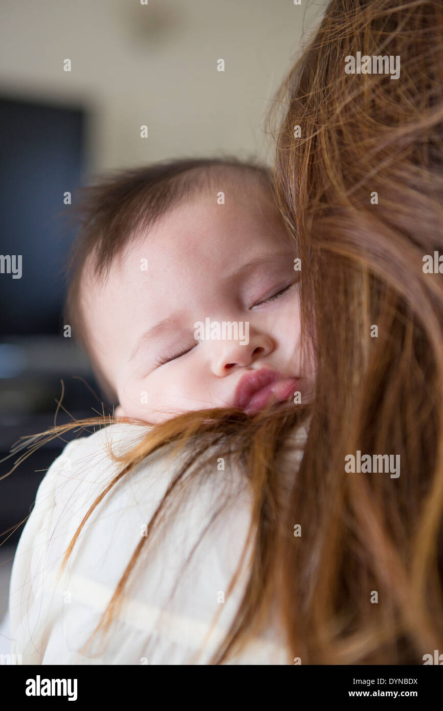 Mother holding sleeping baby girl Banque D'Images