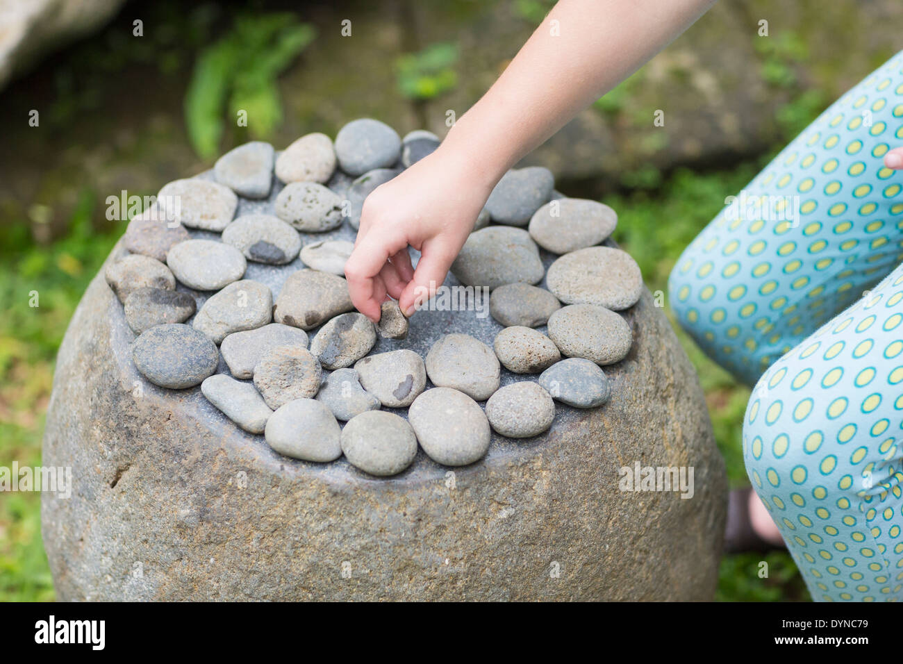Caucasian girl organisant des pierres sur boulder Banque D'Images