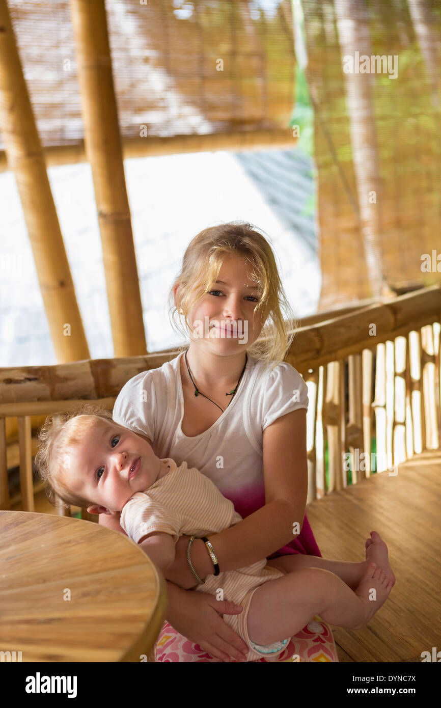 Caucasian girl holding baby sœur Banque D'Images