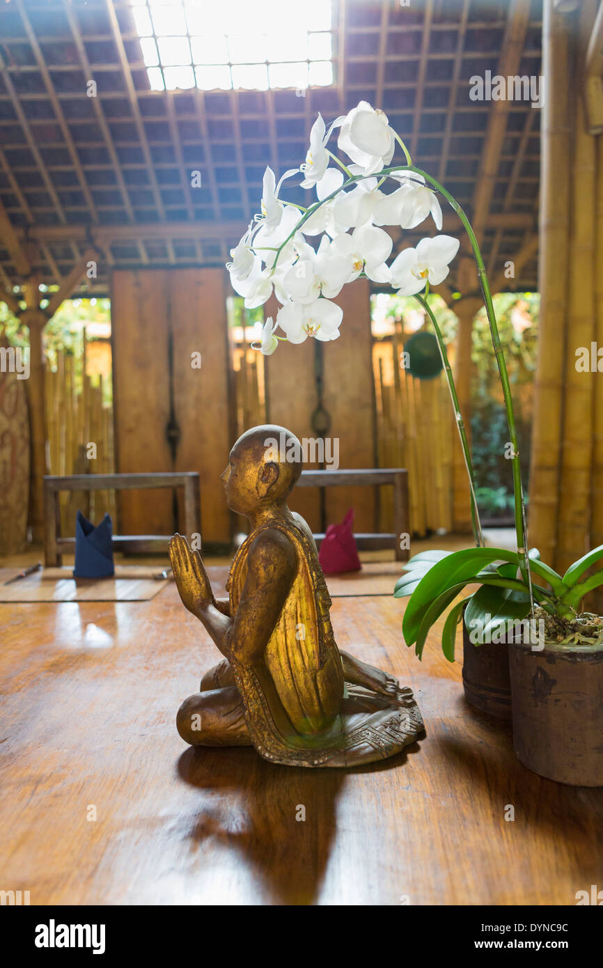 Fleurs et statue dans un temple hindou, Ubud, Bali, Indonésie Banque D'Images