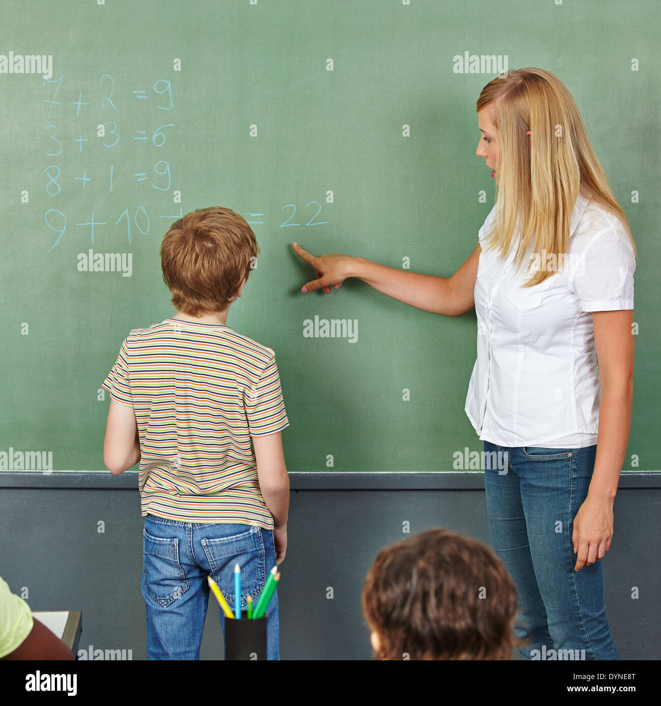 Aider l'enseignant enfant avec problème de mathématiques au tableau dans la classe Banque D'Images