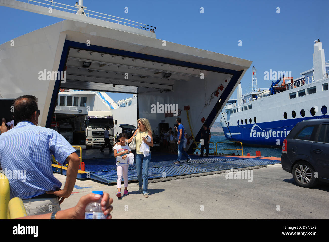 Les véhicules et les gens qui vont sur et hors ferries Igoumenitsa à un port occupé sur le continent nord-ouest de la Grèce Banque D'Images