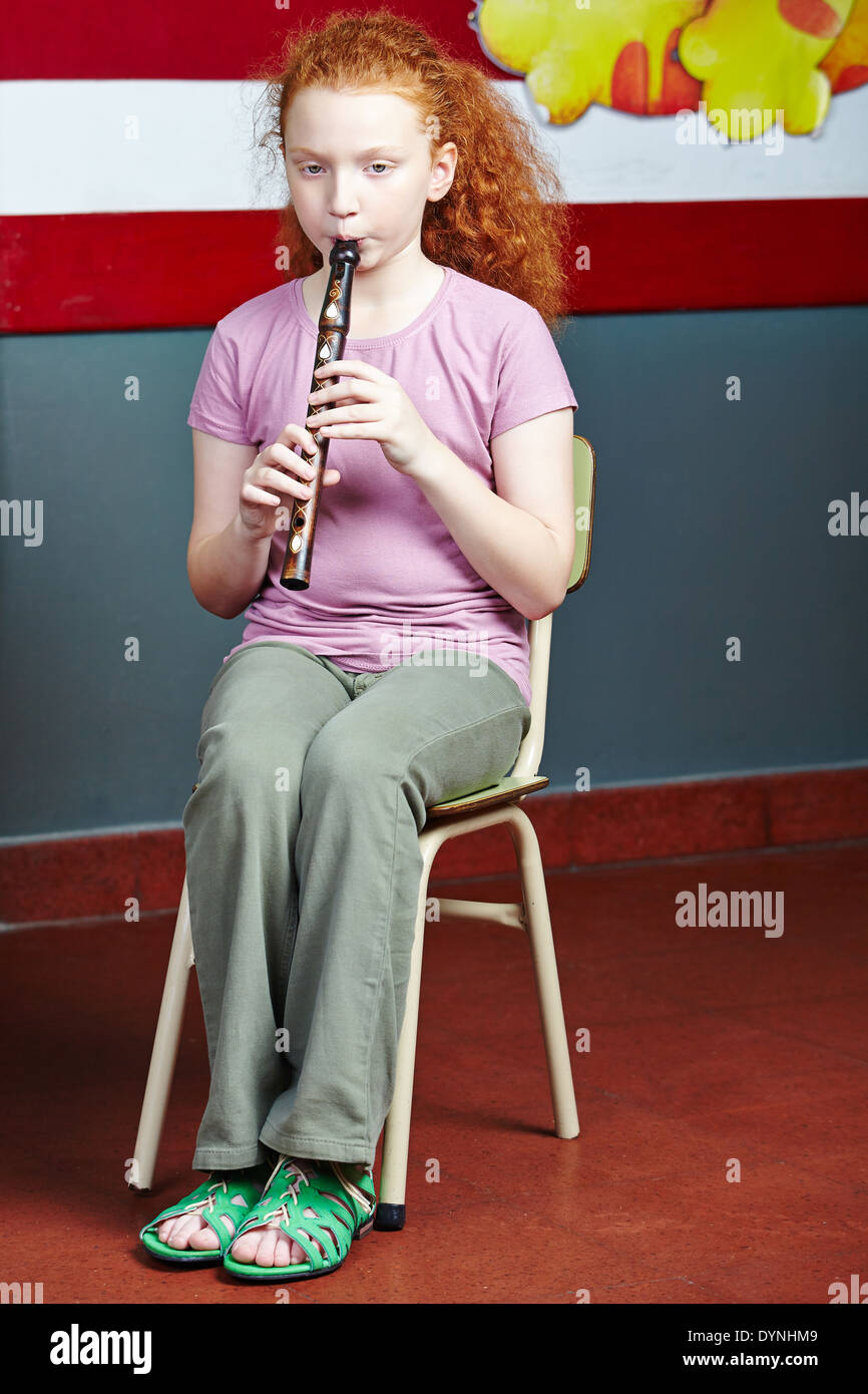 Girl playing flute au cours de musique dans l'école de musique Banque D'Images