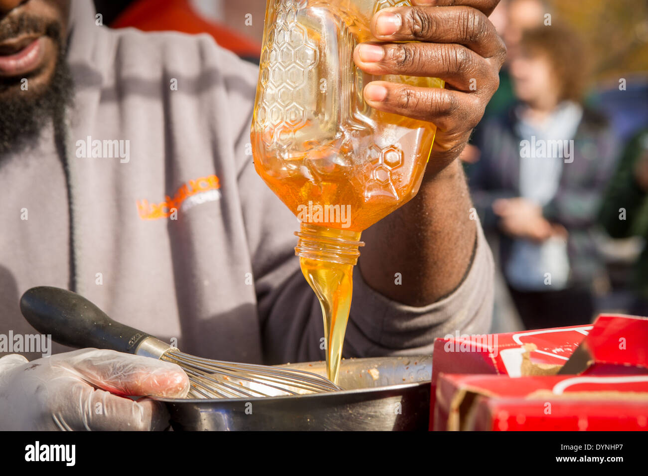 Le miel est versé dans un bol pour faire la sauce à la Waverly Farmers Market à Baltimore, Maryland Banque D'Images