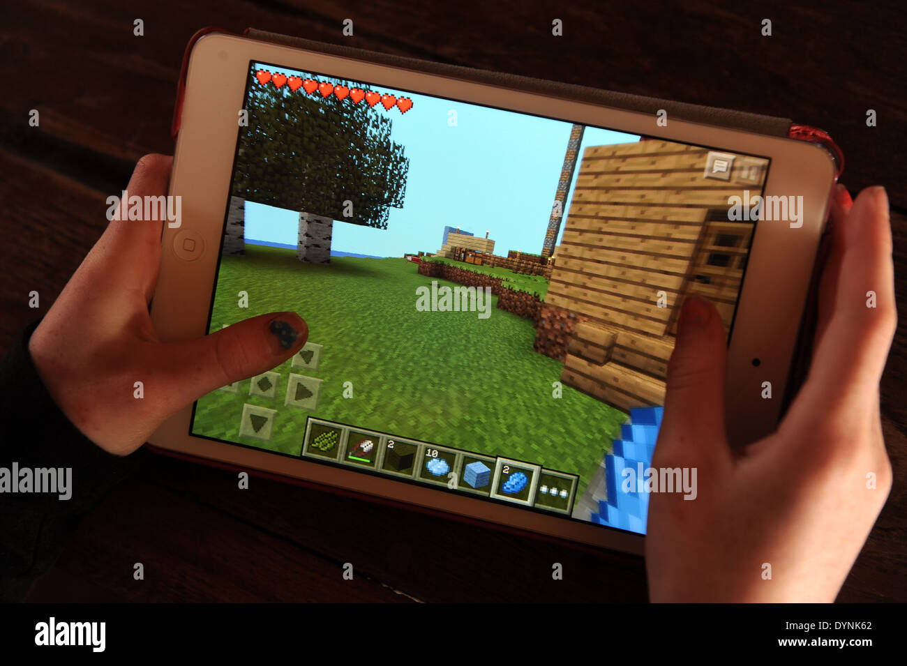 Jeune fille jouant à Minecraft sur un Apple ipad. Banque D'Images