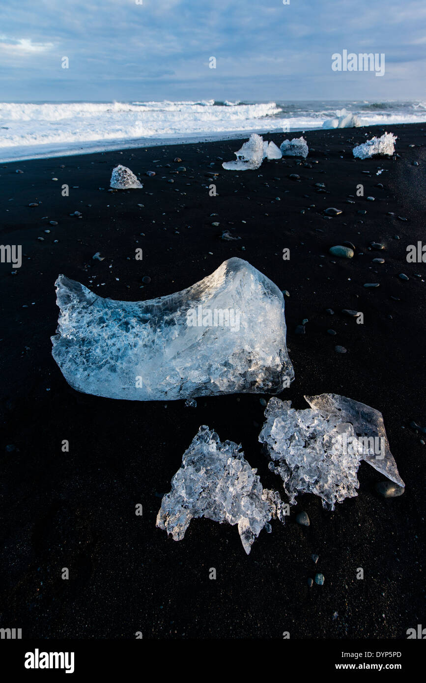 Packs de glace éjectée dérivé du glacier de Vatnajokull sont renvoyés par l'océan Atlantique à la plage de Jokullsarlon, Islande Banque D'Images