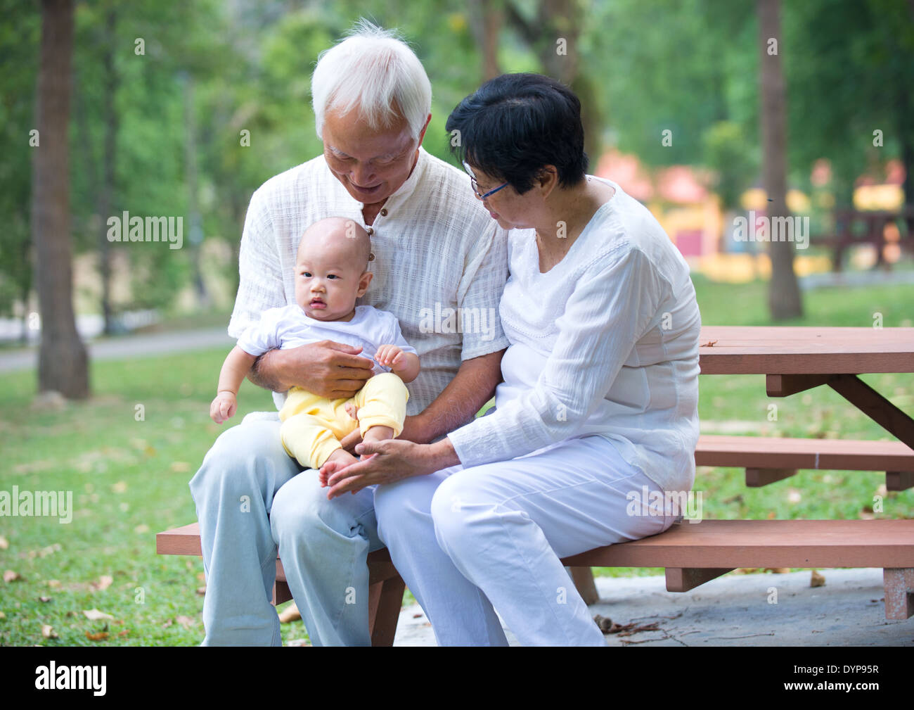 Grand-père chinois jouant avec bébé petit-fils à l'extérieur Banque D'Images