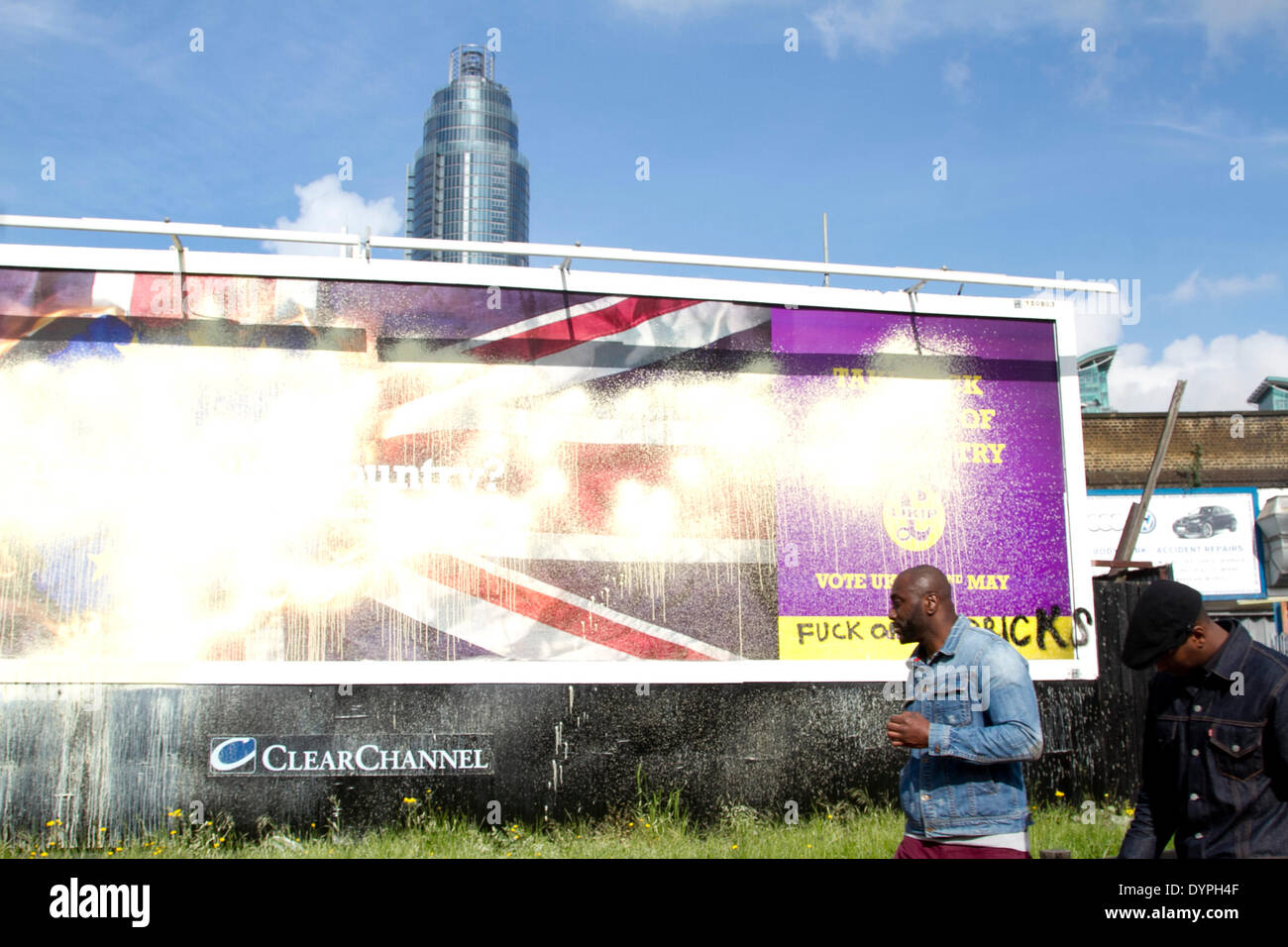 London UK. 24 avril 2014. Les piétons devant une (UKIP) United Kingdom Independence Party affiche de campagne qui a été vandalisé avec de la peinture et graffiti au milieu contre des accusations et l'affiche est raciste après qu'il a été lancé par l'UKIP pour les élections européennes le 22 mai Crédit : amer ghazzal/Alamy Live News Banque D'Images