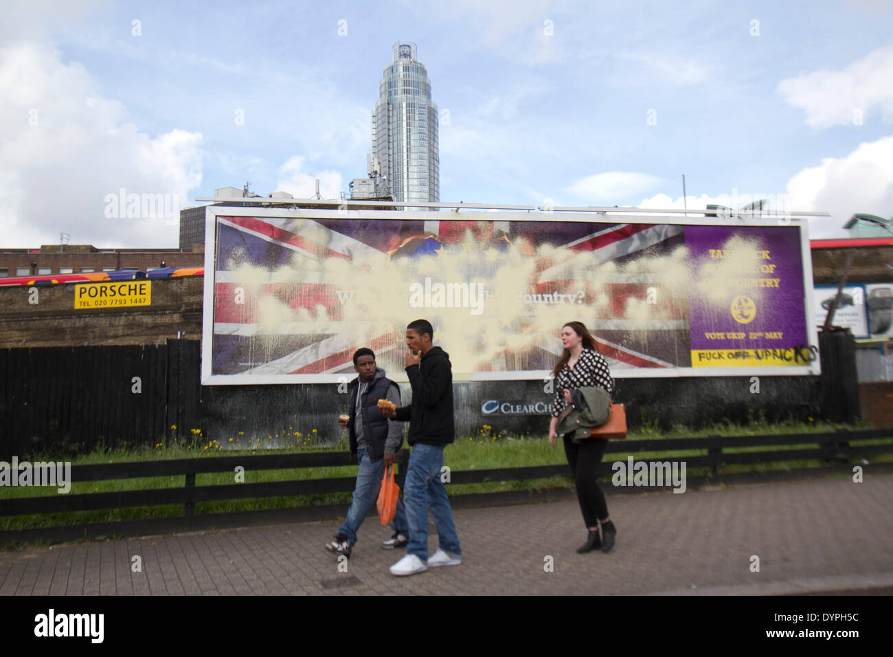 London UK. 24 avril 2014. Les piétons devant une (UKIP) United Kingdom Independence Party affiche de campagne qui a été vandalisé avec de la peinture et graffiti au milieu contre des accusations et l'affiche est raciste après qu'il a été lancé par l'UKIP pour les élections européennes le 22 mai Crédit : amer ghazzal/Alamy Live News Banque D'Images