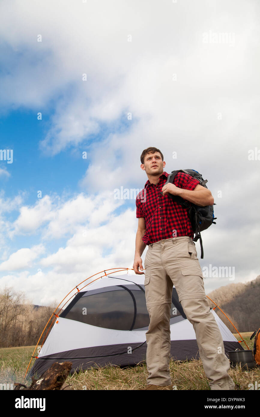Randonneur met en place le camp avec tentes et feu de camp Banque D'Images