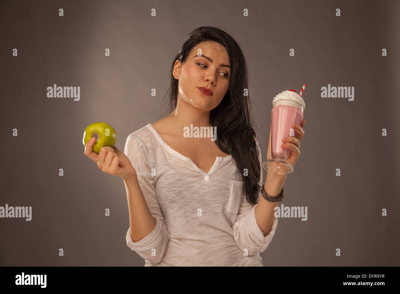 Caucasian girl avec milk shake et apple, faire des choix santé Banque D'Images