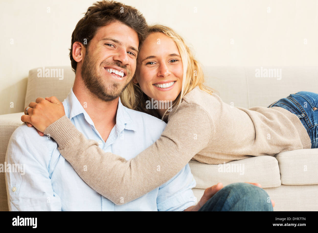 Happy young couple at home détente sur le canapé Banque D'Images