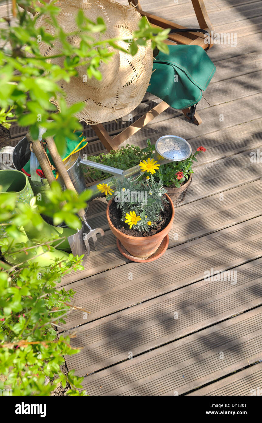 Des pots de fleurs, des outils et plus d'accessoires pour le jardinage sur une terrasse en bois Banque D'Images