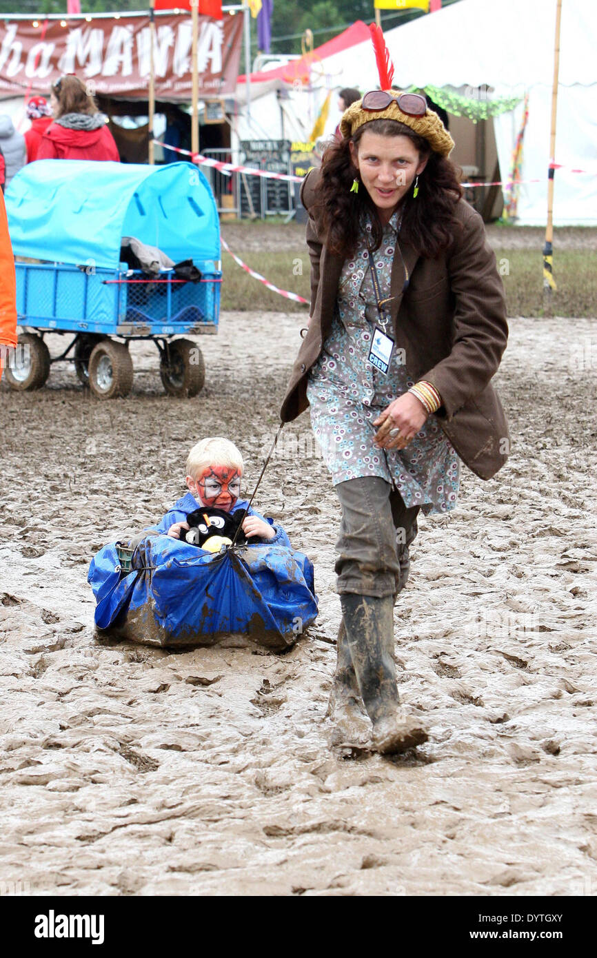Un jeune garçon arrivant à un festival de musique dans le Wiltshire est tiré dans la boue par sa mère dans une caisse. Banque D'Images