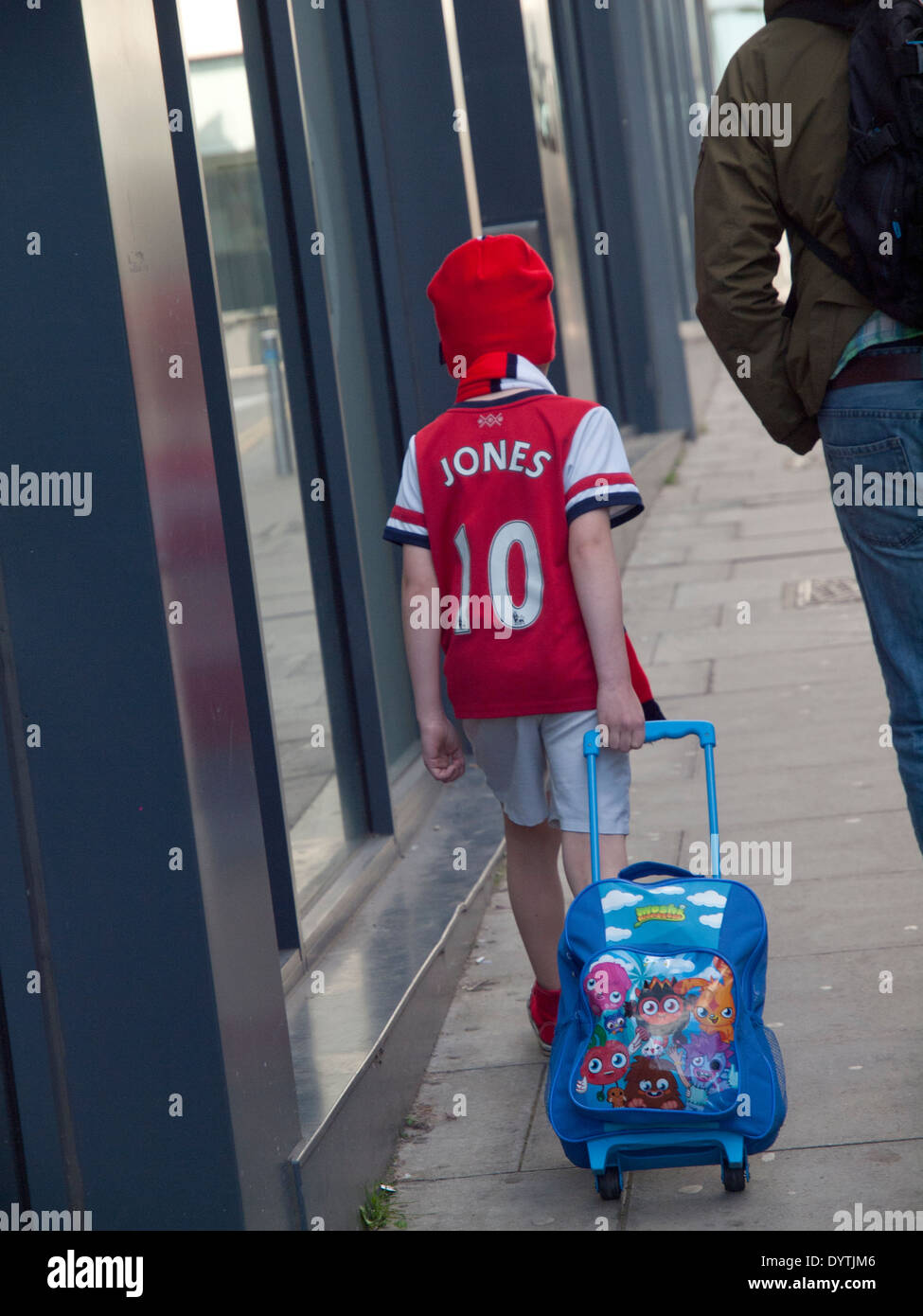 Un jeune fan d'Arsenal son sac roues par le centre de Brighton Banque D'Images