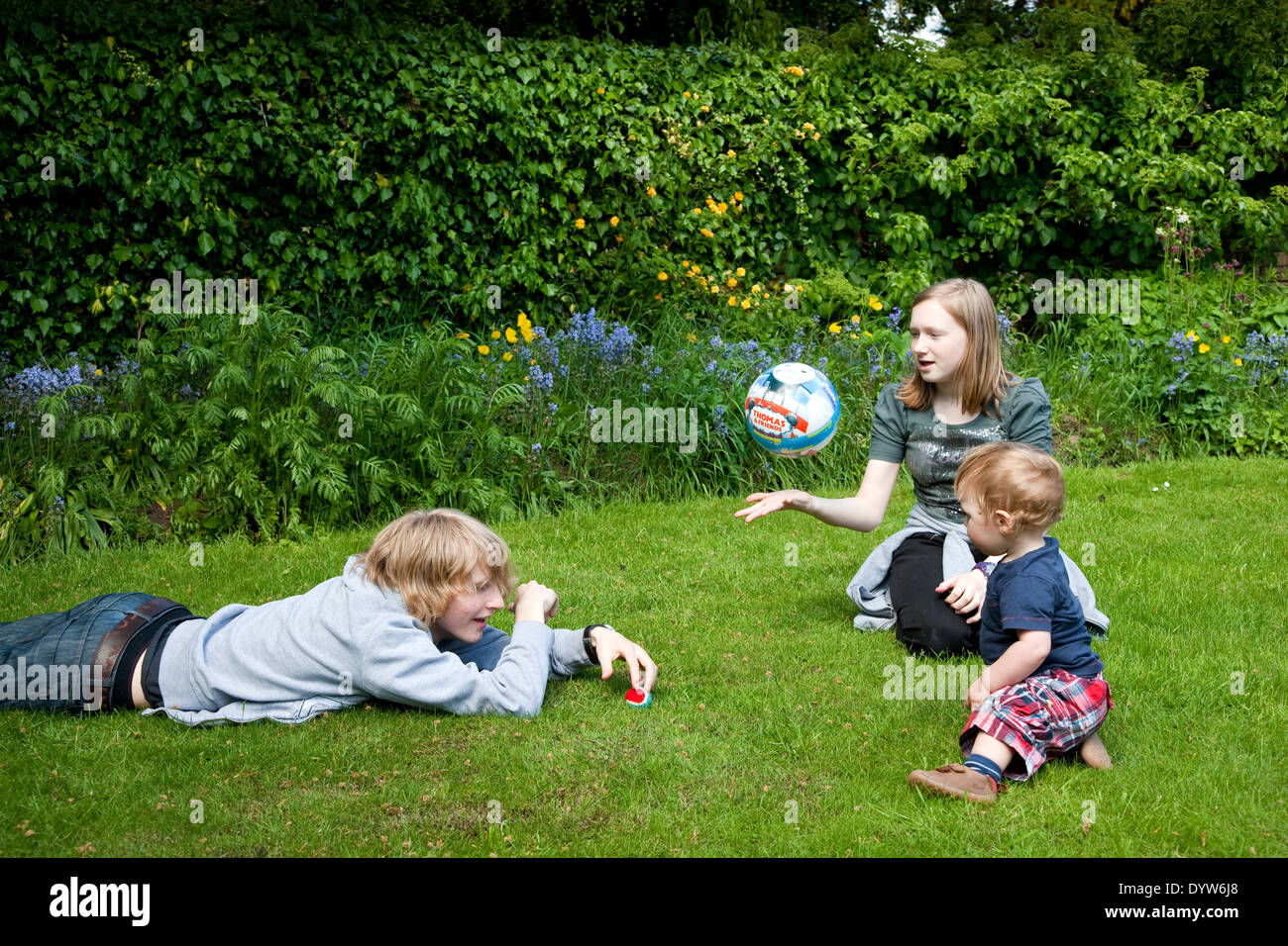 Enfants jouant et s'amusant dans un jardin en été. Adam, Gemma, Thomas Banque D'Images
