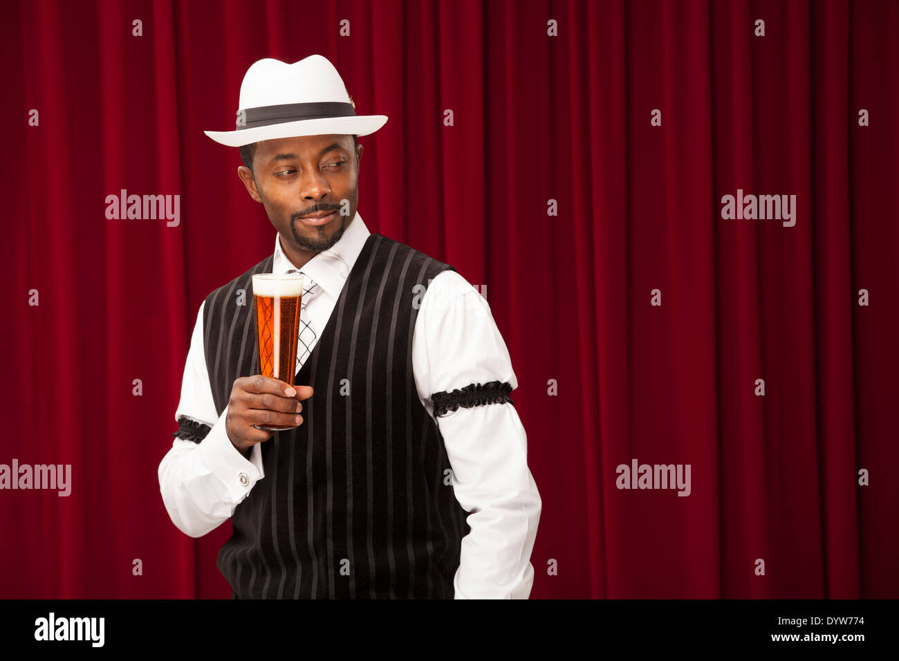Bien habillé, l'homme pourrait être un barman, faisant des références avec sa bière Banque D'Images