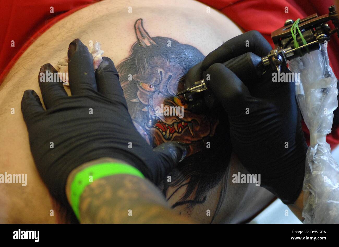 Vancouver, Canada. Apr 25, 2014. Un artiste de tatouage tatouage fait pour un client au tatouage de Vancouver 2014 et culture voir à Vancouver, Canada, le 25 avril 2014. Le week-end événement a rassemblé des artistes de renommée mondiale, leurs conceptions et leurs talents. Crédit : Sergei Bachlakov/Xinhua/Alamy Live News Banque D'Images