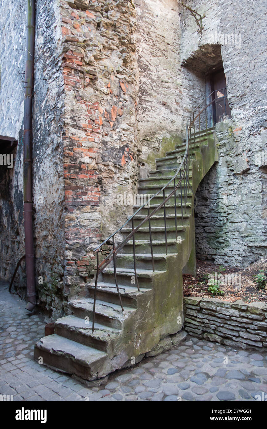 Un vieil escalier en pierre ancienne faite twisted mène jusqu'à une petite porte au mur de pierre. Photo prise dans la vieille ville de Tallinn, Estonie. Banque D'Images