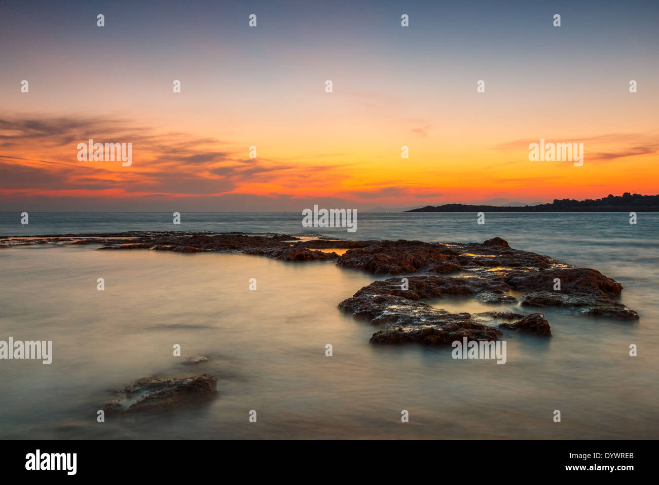 Coucher du soleil orange à la plage en Grèce contre un ciel coloré Banque D'Images