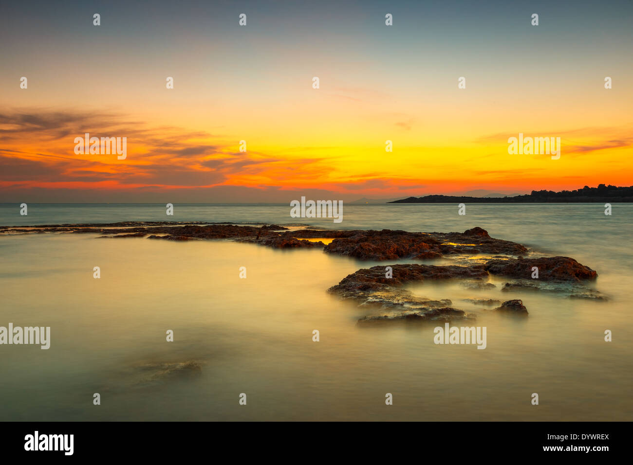 Coucher du soleil orange à la plage en Grèce contre un ciel coloré Banque D'Images