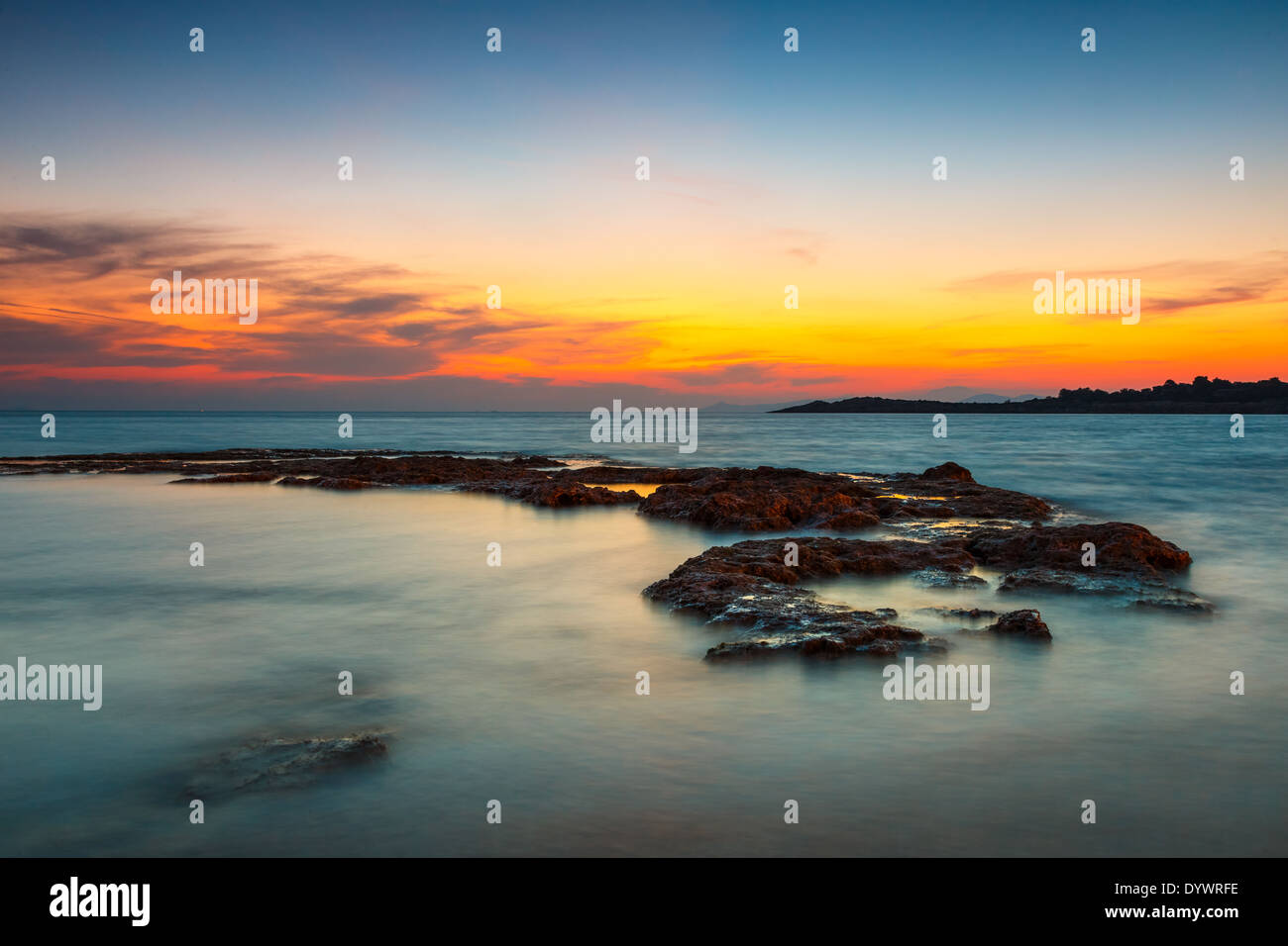 Coucher du soleil orange à la plage en Grèce contre un ciel coloré Banque D'Images