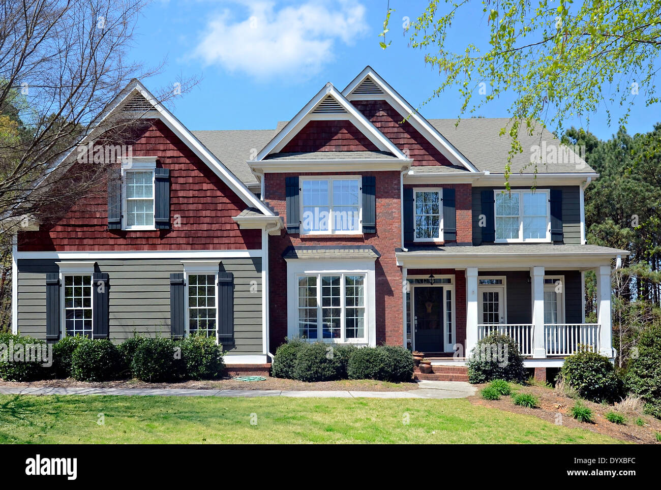L'avant d'une maison de deux étages avec parement de brique et, au début du printemps. Banque D'Images