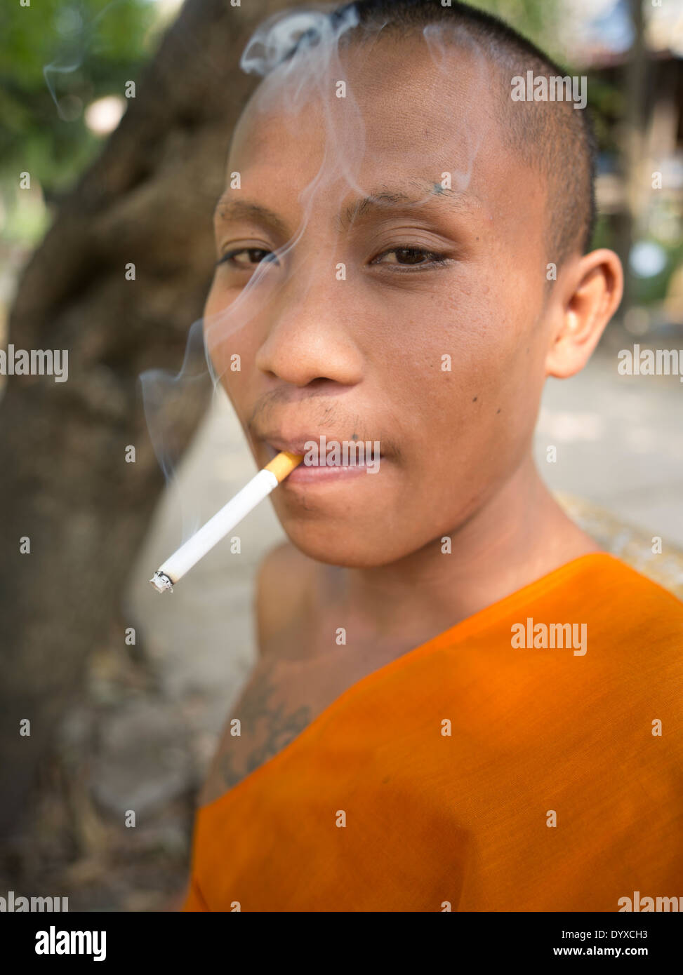 Cigarette jeune moine bouddhiste de Wat Athvea Temple, Siem Reap, Cambodge Banque D'Images