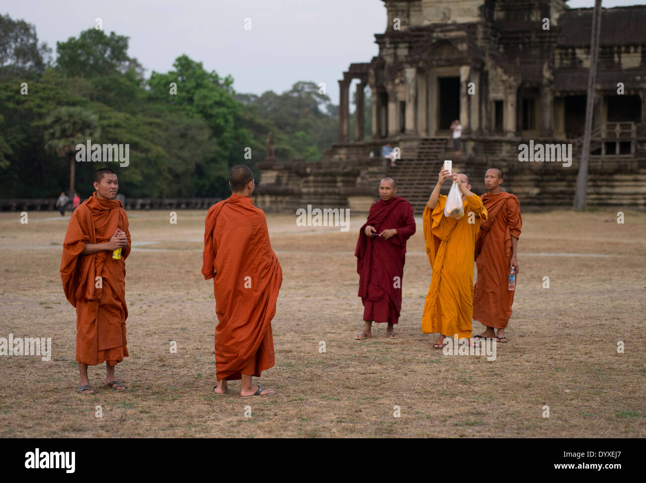 Les moines bouddhistes en robes traditionnelles de prise de photos à Angkor Wat, Siem Reap, Cambodge Banque D'Images