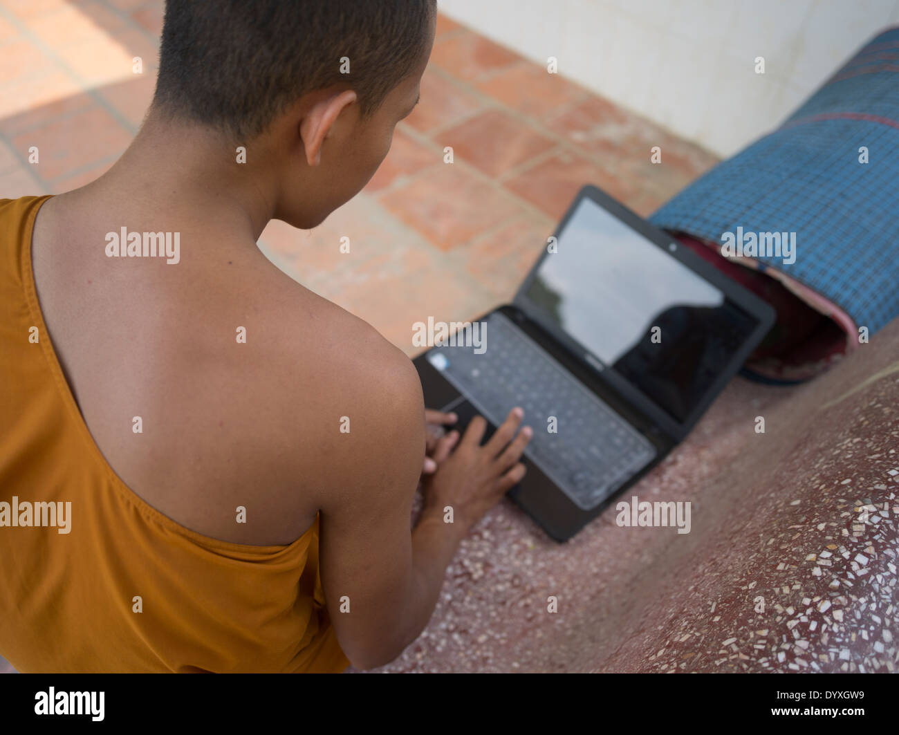 Jeune moine bouddhiste à l'aide d'un ordinateur portable au barrage de Wat Temple Nak, Siem Reap, Cambodge Banque D'Images