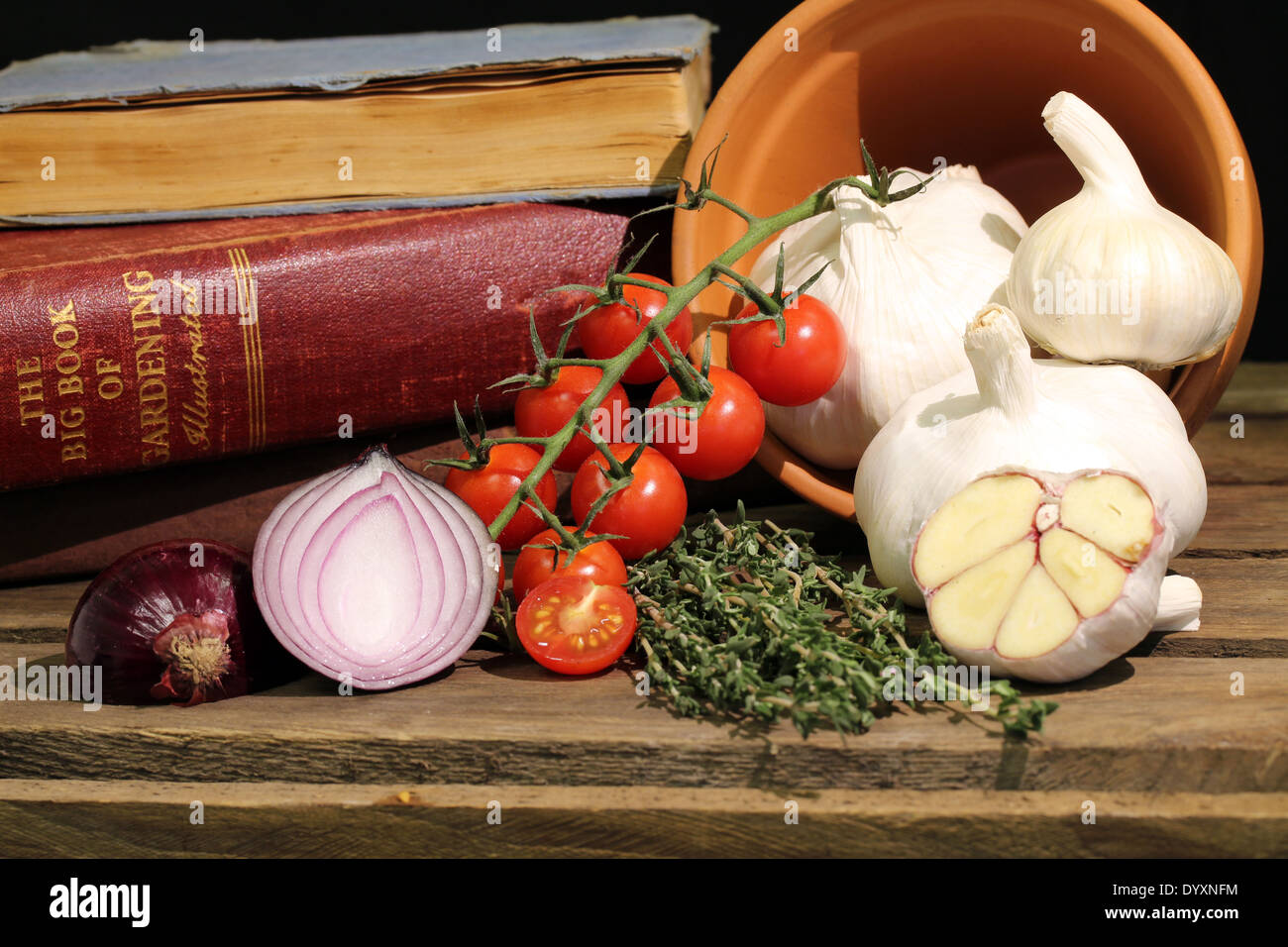 La vie, toujours ensemble l'ail et les couper en tranches, champignons, tomates, herbes, couper l'oignon,livres, plante en pot sur le côté avec des huiles végétales à l'intérieur Banque D'Images