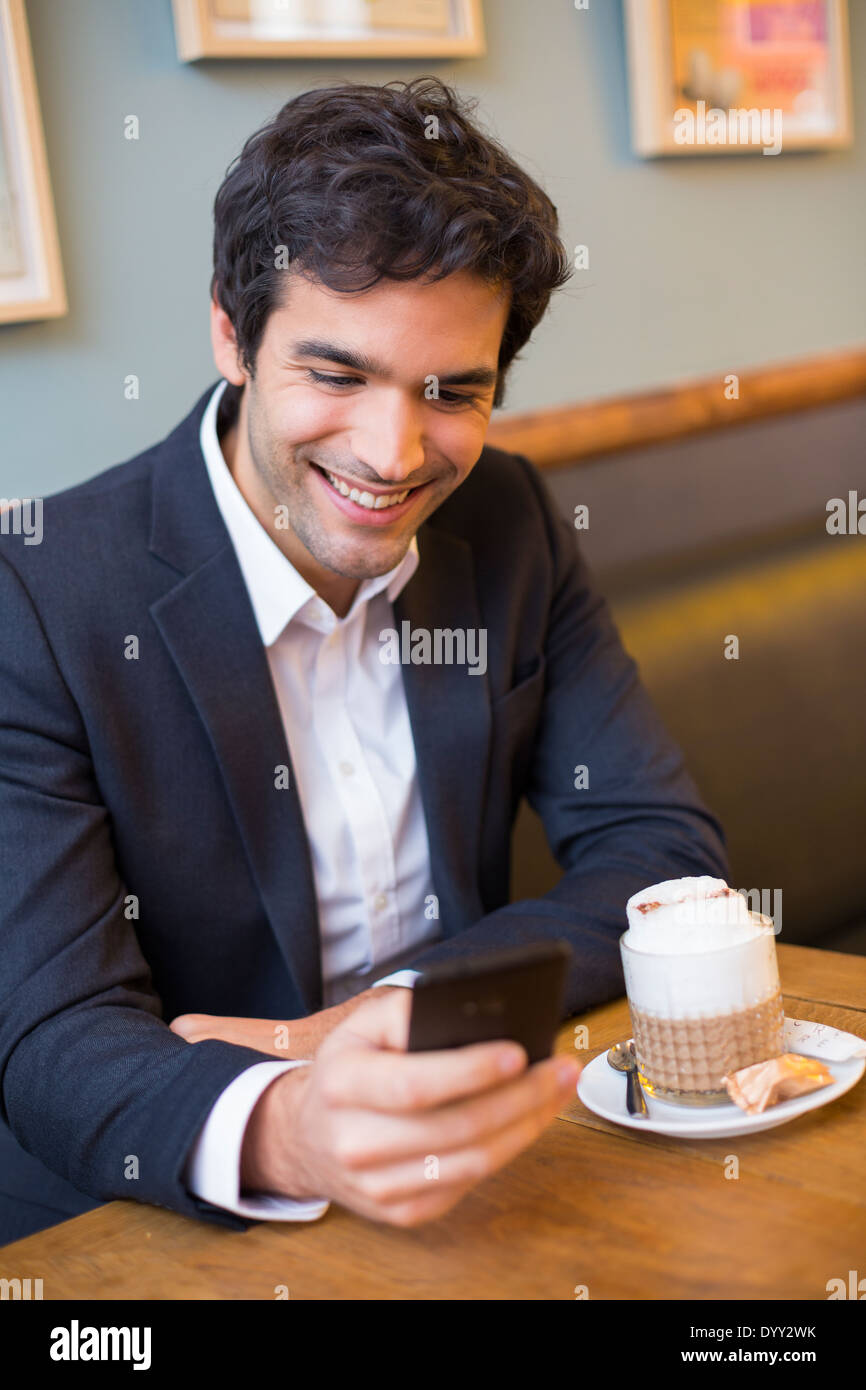 Homme agréable restaurant cafe smartphone sms message Banque D'Images