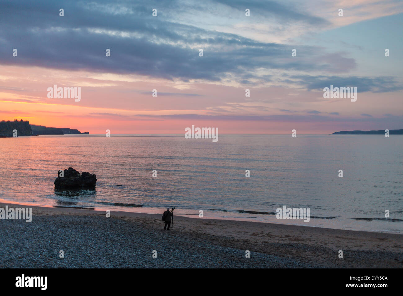 Un photographe au travail sur la plage, à l'heure d'or, Ballycastle, comté d'Antrim en Irlande du Nord Banque D'Images