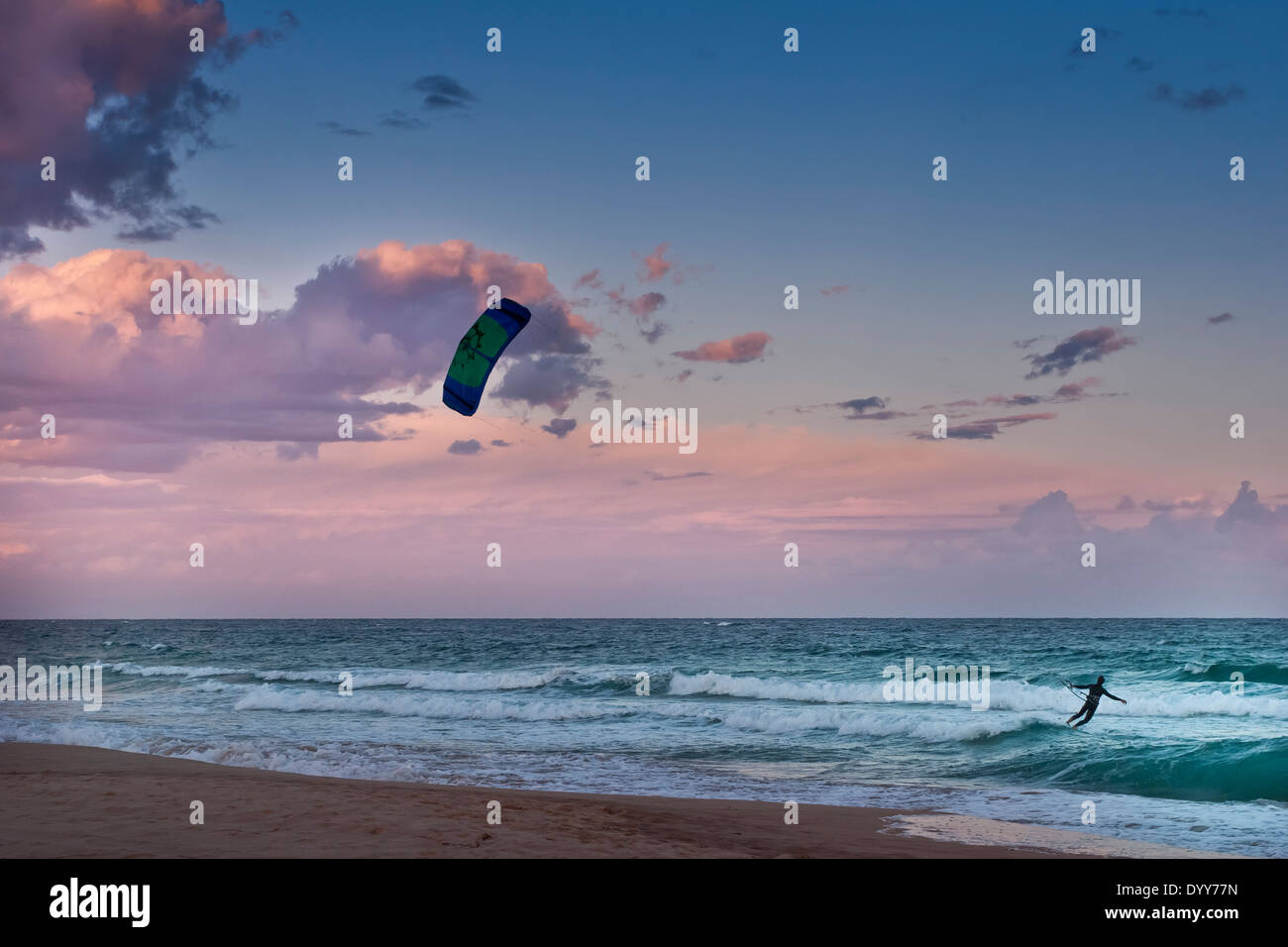 Seule vague kitesurf sur aqua bleu océan dans les vagues près de la côte avec lavande et spectaculaire coucher du soleil bleu Australie Banque D'Images