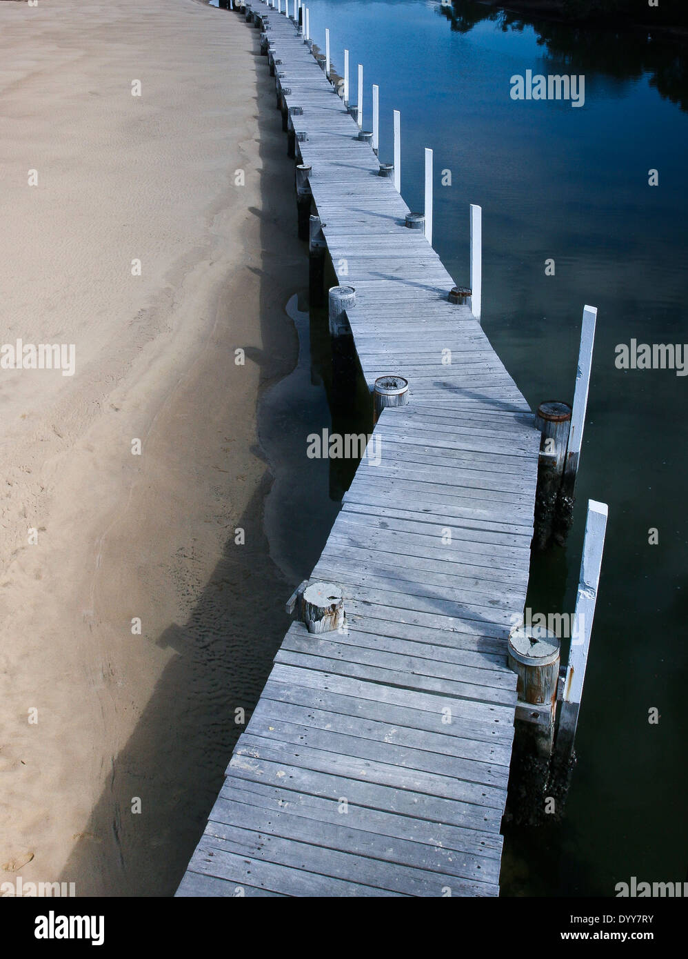 Photo prise à la verticale sur la jetée de bois Macleay river avec la moitié de l'eau tranquille et la moitié de l'Australie de sable Banque D'Images