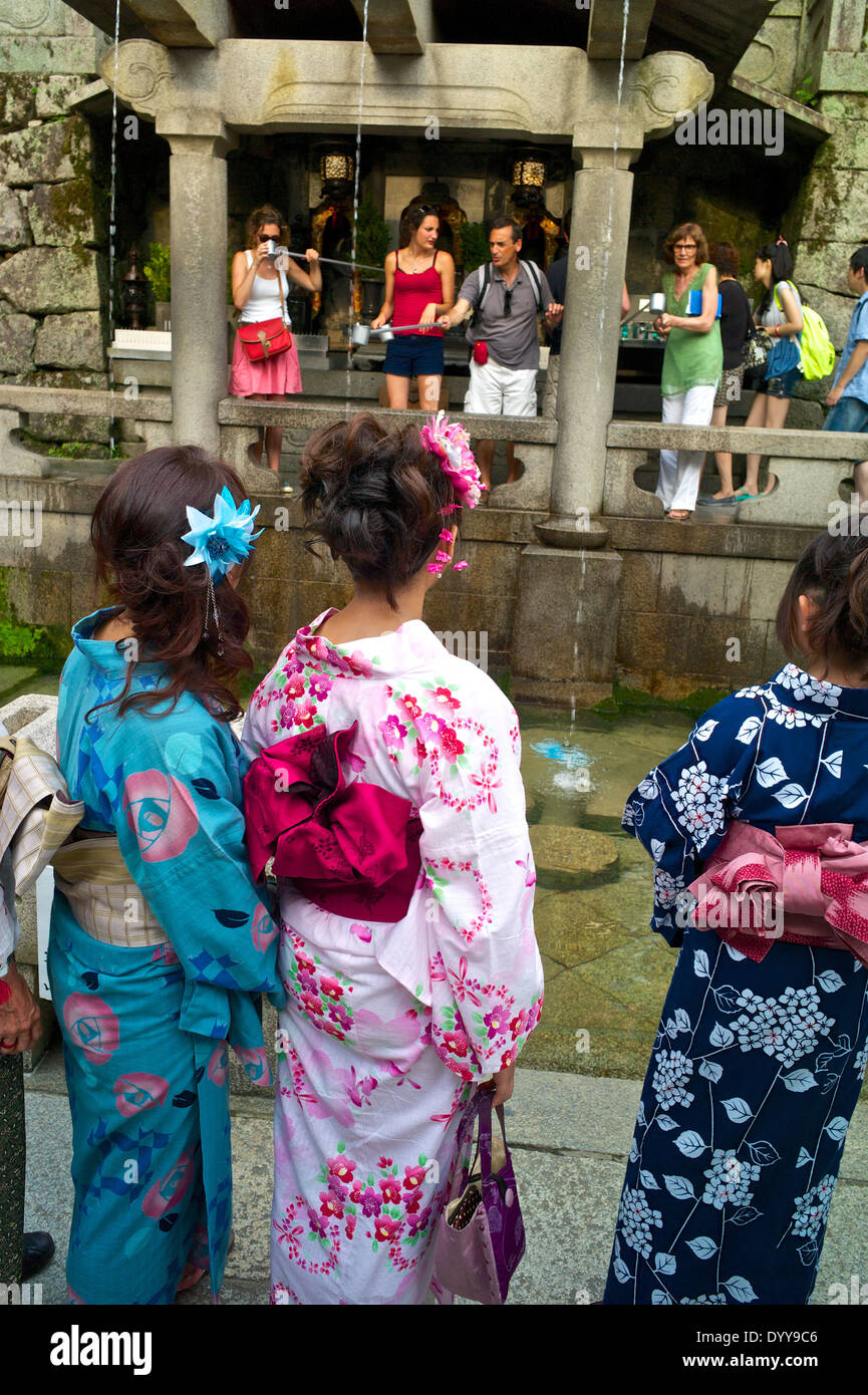 Les touristes tentent d'obtenir l'eau qui tombe de la Ottawa-no-taki waterfall avec métal tasses au temple Kiyomizu-dera. Banque D'Images