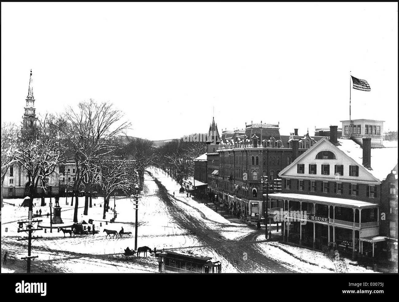 Cette image représente le côté est de Central Square à Keene, dans le New Hampshire, mettant en valeur les quartiers d'affaires historiques de la ville. La représentation met en évidence des bâtiments, des hôtels de ville et des tramways de la fin du XIXe siècle au début du XXe siècle, représentant le développement urbain de Keene. Banque D'Images