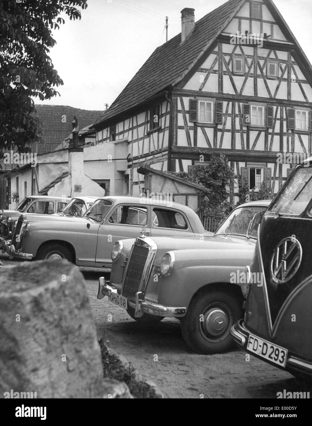 Scène de village avec maison à colombages et voitures dans les années 50 Banque D'Images