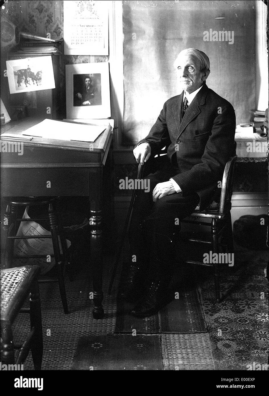 Portrait d'un homme de Keene, New Hampshire, que l'on croit être Bion Whitehouse, pris dans son bureau ou son espace de travail. La photographie reflète l'histoire locale de Keene, mettant en valeur un moment vintage dans la vie quotidienne d'un individu au milieu du XXe siècle. Banque D'Images