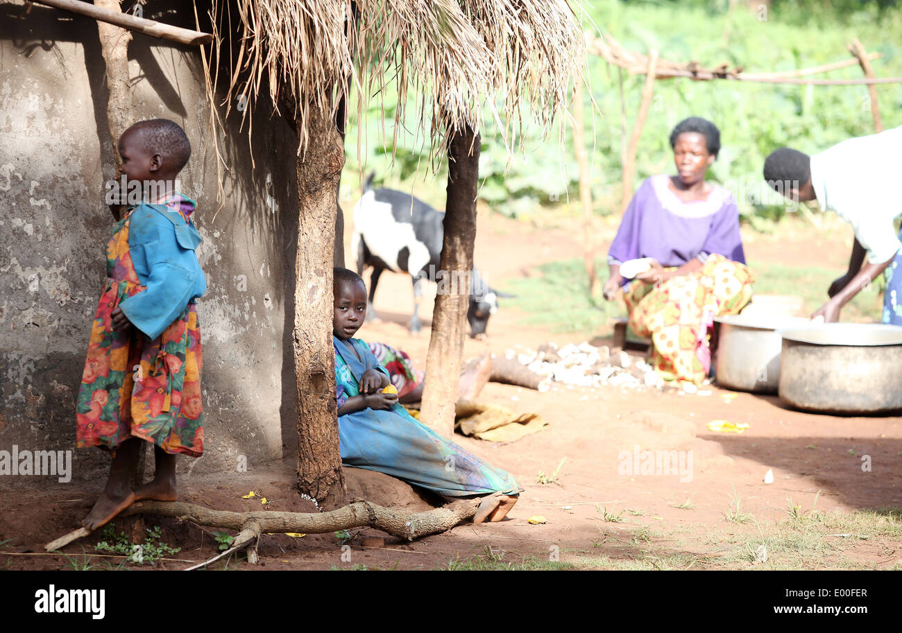 Un jeune enfant regarde les femmes préparent la nourriture dans une zone rurale de la district de Lira, dans le nord de l'Ouganda. Banque D'Images